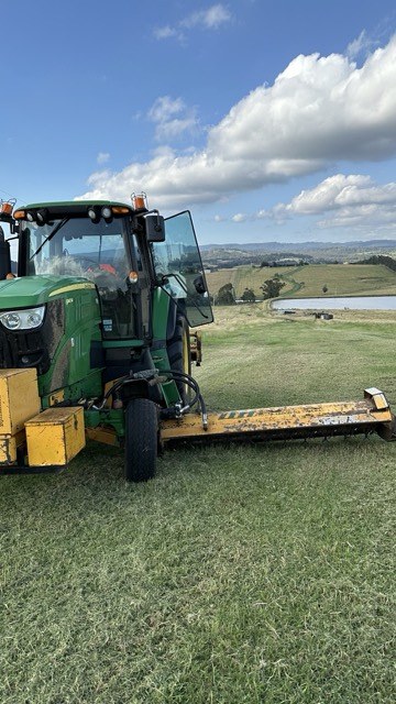 Alamo Interstater cutting a hillside paddock above a lake