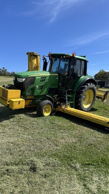 John Deere tractor with the Alamo side-arm deck folded up for travel